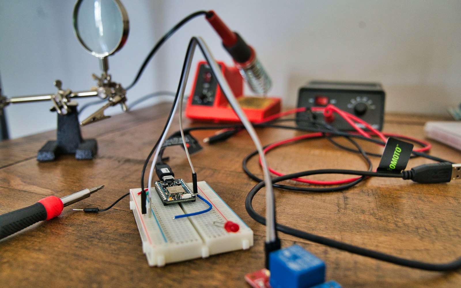 Electronics workbench with a breadboard, soldering iron and test leads